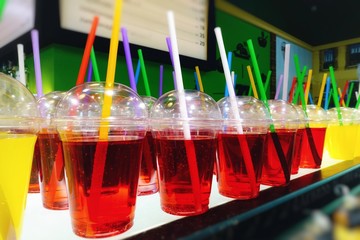 Assortment of colorful drinks in transparent plastic glasses