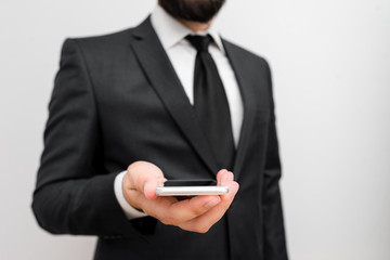 Male human wear formal work suit hold smart hi tech smartphone use one hand