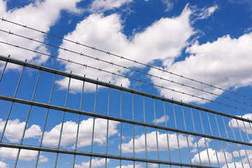 Fototapeta na wymiar Restricted Area Concept. Metal Fence with Barbed Wire. 3d Rendering