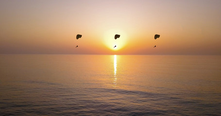Paragliding at sunset. Image of Amazing sunset over sea. Summer sunset seascape.