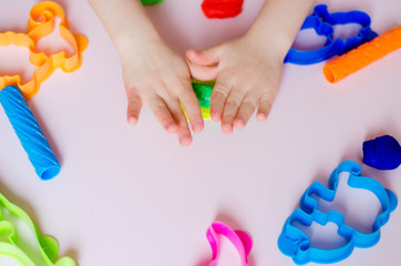 Child hands playing with colorful clay. Homemade plastiline. Plasticine. play dough. Girl molding modeling clay. Homemade clay.