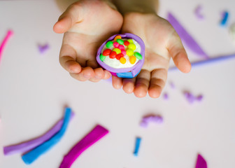 Child hands playing with colorful clay. Homemade plastiline. Plasticine. play dough. Girl molding modeling clay. Homemade clay.