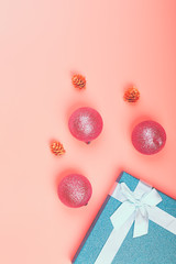 Blue glitter gift box with ribbon and Christmas toys on a pink background. minimalistic christmas background with empty place for text