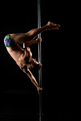 Photo of guy performs acrobatic trick on pole