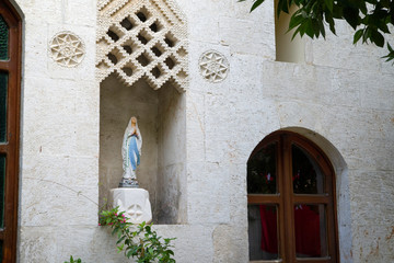 Fototapeta na wymiar statue of mother mary on the external wall of the catholic church of antioch 