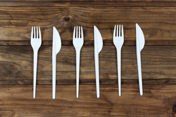 set of plastic cutlery, on a wooden table, copy spaсe