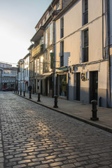 Santiago de Compostela landmark. Old narrow medieval street. Empty street in morning sunshine. Camino de Santiago concept. European architecture. Pilgrimage centre. Travel in Spain.