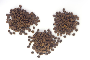  three heaps of coffee beans on a white background. Flat lay