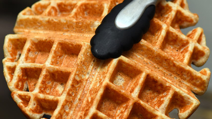 Whole wheat waffle with tongs macro