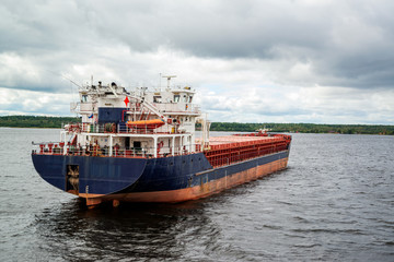 Barges with cargo swimming along the banks of the north-west river