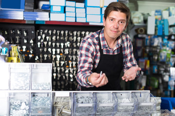 Worker man in hardware store is trading goods for construction