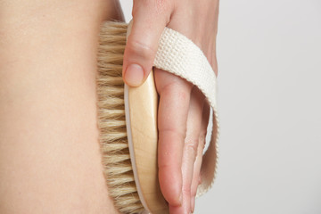 Dry body brush, Woman dry brushing body to reduce cellulite, detoxify the lymphatic system, and...