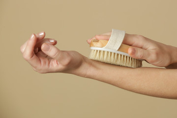 Dry body brush, Woman dry brushing body to reduce cellulite, detoxify the lymphatic system, and achieve beautiful smooth skin. Dry skin brushing as part of morning health and energy routine.