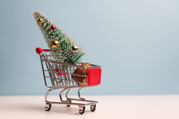 Christmas tree in a shopping cart. Christmas shopping and preparations concept
