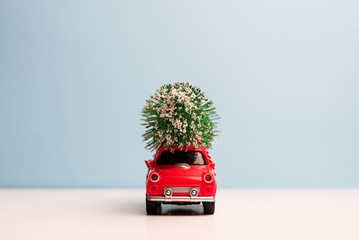 Red car carrying a Christmas tree