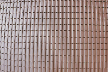 Brown metal tile on the roof of the house. Corrugated metal roof