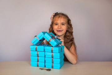 Cute girl near blue gift boxes formed like a house