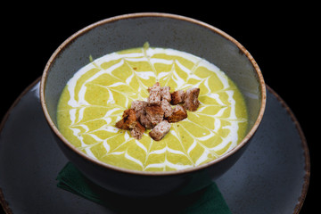 Creamy decorated vegetable soup in a rustic bowl 