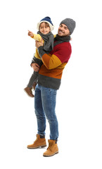 Happy father and son in warm clothes on white background. Winter vacation