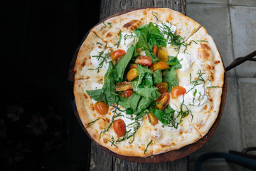 Fresh italian pizza with tomatoes, cheese, basil on black wooden background. Copy space. Homemade with love. Fast delivery. Recipe and menu. Top view.