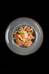 Homemade pasta with chicken, cheese and piece of carrot in a rustic plate