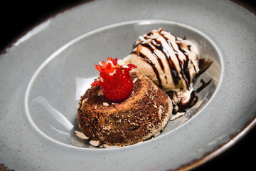 Fresh chocolate souffle with vanilla ice cream on a grey rustic plate