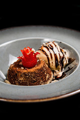 Fresh chocolate souffle with vanilla ice cream on a grey rustic plate
