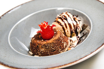 Fresh chocolate souffle with vanilla ice cream on a grey rustic plate