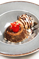 Fresh chocolate souffle with vanilla ice cream on a grey rustic plate