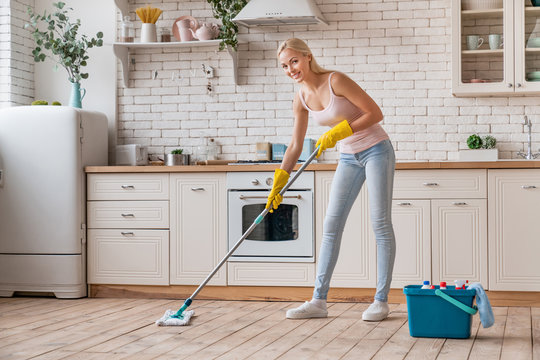 Woman With Mop Cleaning Kitchen Floor