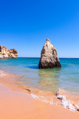 Fototapeta premium LANDSCAPE OF THE SEA WITH GREAT ROCK IN THE CENTER AND HORIZON OF BLUE SKY IN THE COAST OF PORTUGAL 