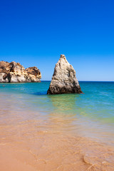 LANDSCAPE OF THE SEA WITH GREAT ROCK IN THE CENTER AND HORIZON OF BLUE SKY IN THE COAST OF PORTUGAL