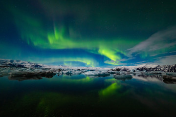 Naklejka na ściany i meble Aurora Borealis over a glacier lagoon in Iceland