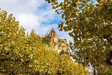 Naklejka premium Сastle on a towering mountain amid autumn foliage. Chateau de Beynac in the village Beynac-et-Cazenac. France. 26 nov 2019