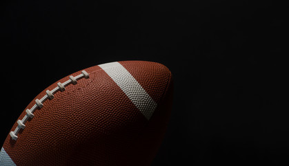 American football ball close up on black background.