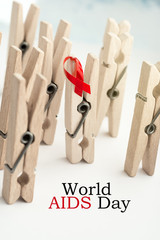  wooden clothespins symbolize people with Red ribbon - World AIDS day