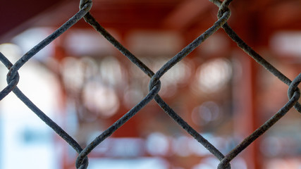 Wire fence with blurry background symbolizing togetherness