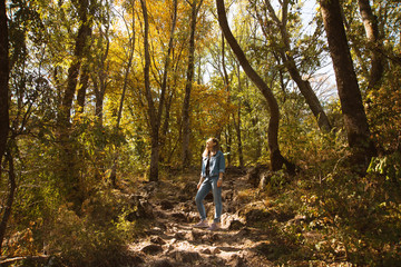 A young woman is standing in the middle of the forest.
