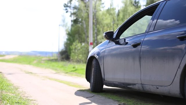 Woman hand throw clear bottle with blue cap out from dirty car window to the forest road. concept human garbage destroy environment.