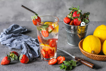 Photo of refreshing Strawberry infused waters. Mineral water with fresh strawberries lemon with a grey background. Detox water with strawberry lemon. Copy space.