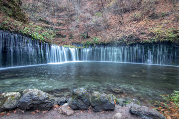 beautiful wide waterfall surrounded by autumn