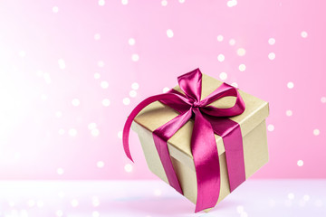Gift box red ribbon isolated on pink background. Xmas present. Christmas surprise. Festive backdrop for holidays Birthday