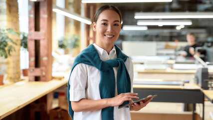 Positive attitude is winning key. Confident asian office worker posing indoors