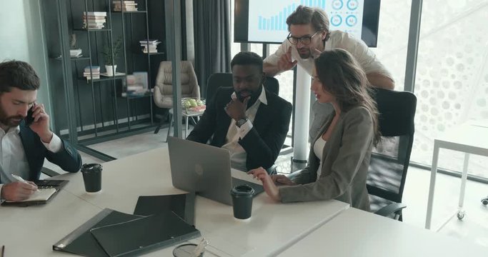 Busy Bisness People working in the Modern Office, Using Laptop and Digital Board. Successful Colleagues Discussing Projects in the Office. Looking Serious. Workers group in teamwork.