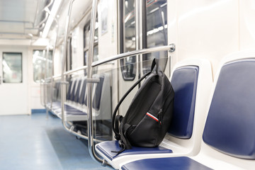 Forgotten leather black backpack/bag or bomb to commit a terrorist attack lies on a seat in subway...