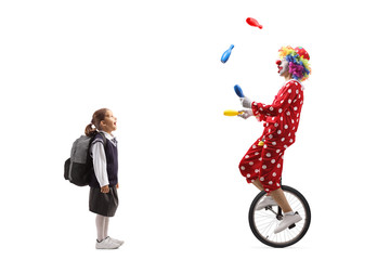 Excited little schoolgirl looking at a mime juggling and riding a unicycle © Ljupco Smokovski