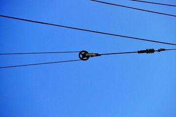 Electrical wires against the blue sky