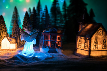 New Year miniature house in the snow at night with fir tree.