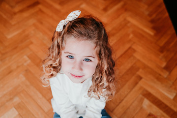 kid girl decorating christmas tree at home. holding a golden snow flake. Christmas concept