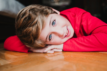 portrait of beautiful kid boy at home wearing a red pajama. Happy kid. Christmas season